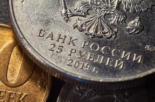 Banknotes and coins of the Russian ruble. Details of Russian money in close-up.The inscription Bank of Russia on the coin.The Russian symbol of the double-headed eagle