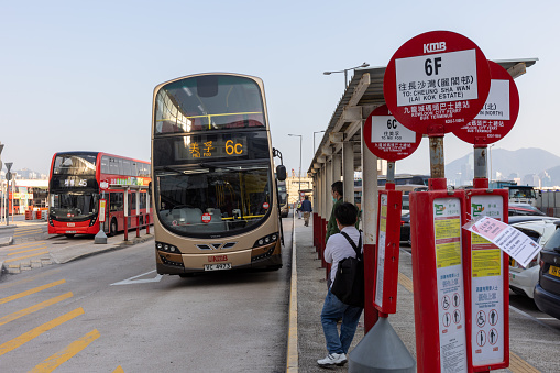 Hong Kong - March 4, 2022 : Passengers waiting bus at the Kowloon City Ferry Bus Terminus in Kowloon, Hong Kong. Bus Route 6C is going to Mei Foo.