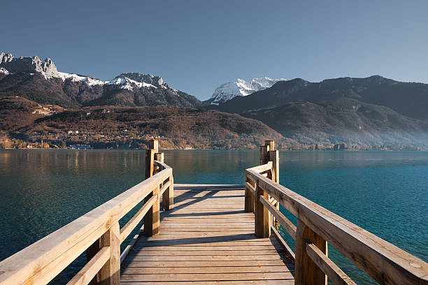 Snow capped  French Alps mountains seen from a pier on Annecy Lake