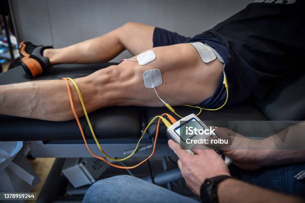 Muscle Stimulator Device With Electrodes Applied To Quadriceps By A  Professional Physiotherapist Stock Photo - Download Image Now - iStock
