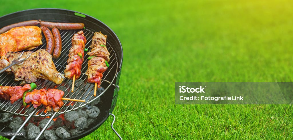 Delicious grilled meat with vegetables sizzling over the coals on barbecue Barbecue Grill Stock Photo