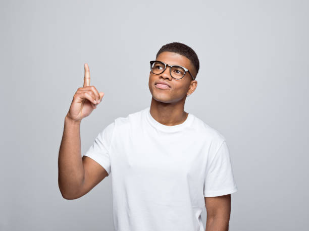 Cheerful young man pointing at copy space