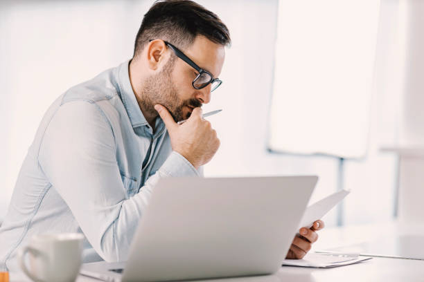istock A focused man reading paperwork at home office. 1379013773
