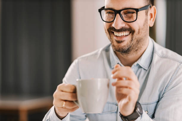 istock A happy man holding mug with coffee or tea and smiling. 1379016324