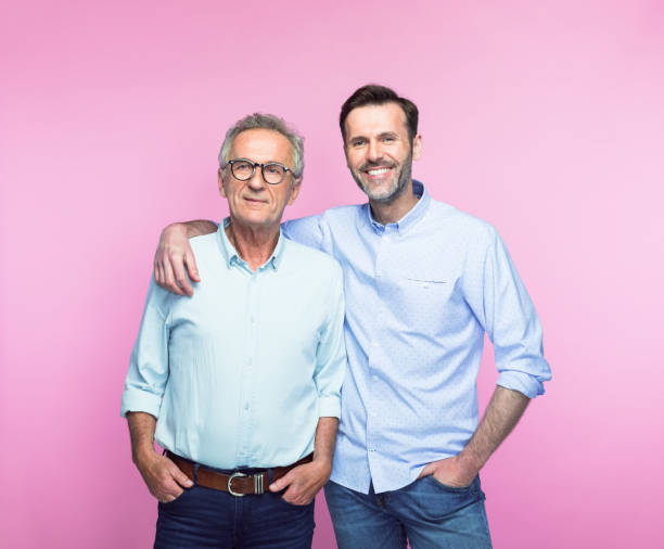 uomo sorridente con il braccio intorno al padre anziano - gray hair immagine foto e immagini stock