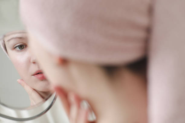 istock Beautiful attractive smiling woman paints lips with red lipstick using a small round mirror during home makeup in the morning. 1379053058