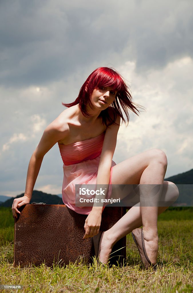 Jeune fille assise sur une valise - Photo de 20-24 ans libre de droits