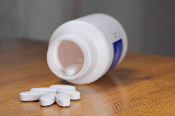 抗放射線薬、ヨウ素錠剤、白い医療瓶と木製のテーブル上の放射線防護のための錠剤 - capsule pill white nutritional supplement ストックフォトと画像