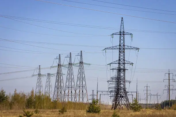 Photo of High voltage power line on industrial electricity line tower for electrification rural countryside