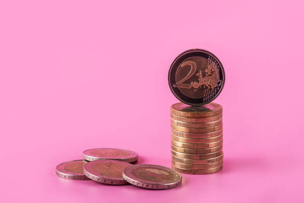 1 and 2 euro coins on a pink background