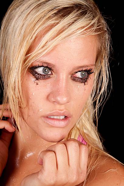 Portrait of a pretty young blonde woman with mascara running down her face after crying