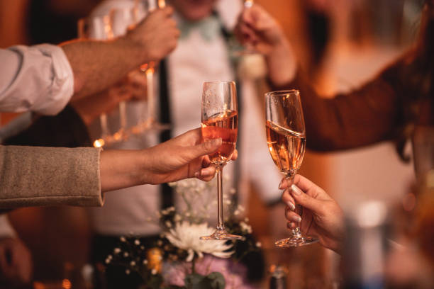 Group of people Celebratory toast cheers champagne flute with string fairy lights Group of people Celebratory toast cheers champagne flute with string fairy lights political party stock pictures, royalty-free photos & images