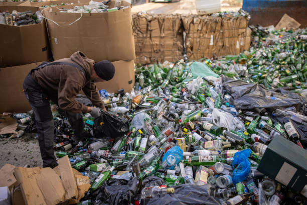 Senior male Caucasian worker, working at the recycling center, separating the recycling material