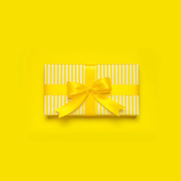istock Flat lay holiday background. Bright yellow gift present box with ribbon and bow on yellow background top view copy space. Birthday present, March 8, Mother's Day, Valentine's Day. Congratulation 1379141719