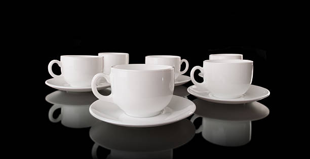 istock White cups and saucers on a black background 137914427