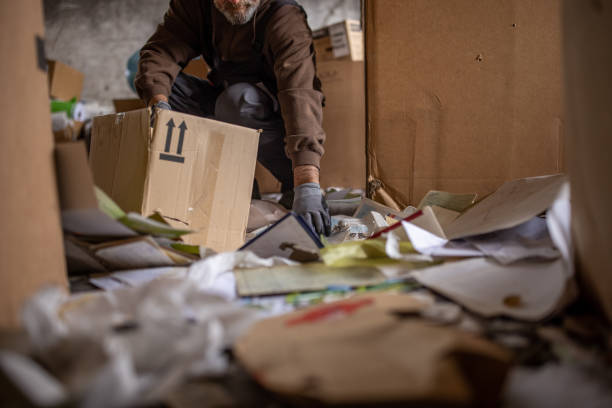 istock Senior male worker separates the material for recycling from garbage 1379157936