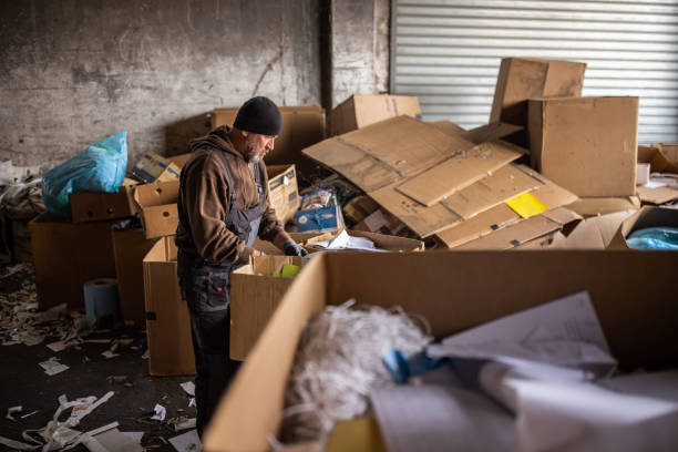istock Senior male worker separates the material for recycling from garbage 1379157939