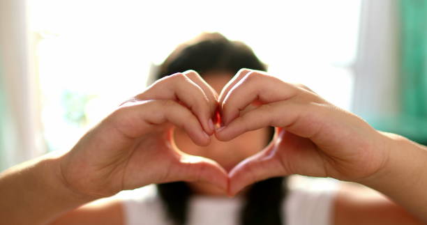 istock Cute child doing heart symbol sign with hands 1379162236