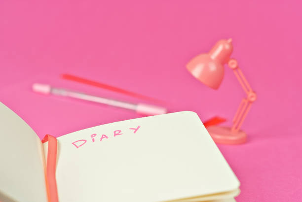istock Notebook on a pink background. Toy table lamp near the notebook. Copy space and free space for text in notebook. Mockup for design. The word 