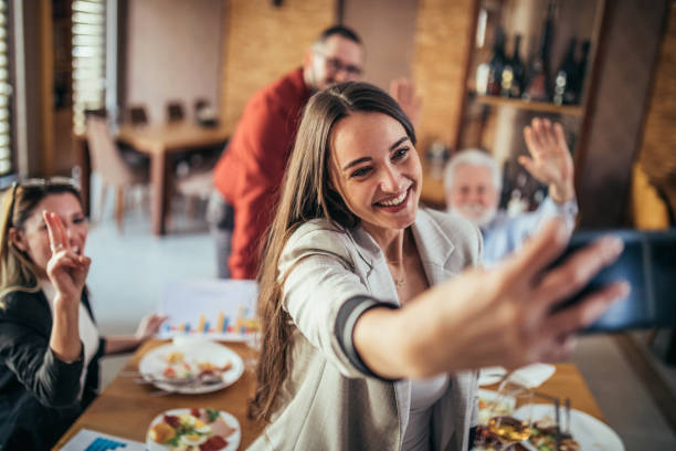 businesspeople taking a selfie together in a restaurant stock photo
