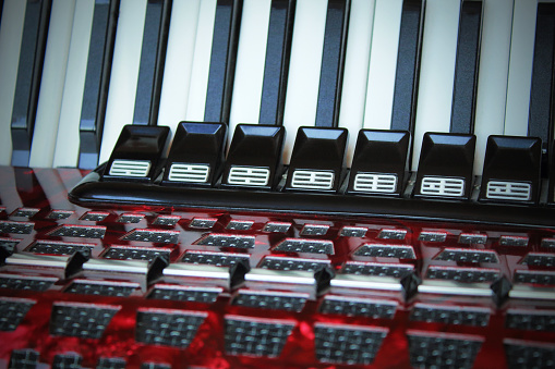 Beautiful red old accordion. Keys and buttons close up. Front view. Background. Texture.