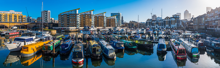 Colourful narrow boats moored in Limehouse Basin along the River Thames in the heart of London, UK.