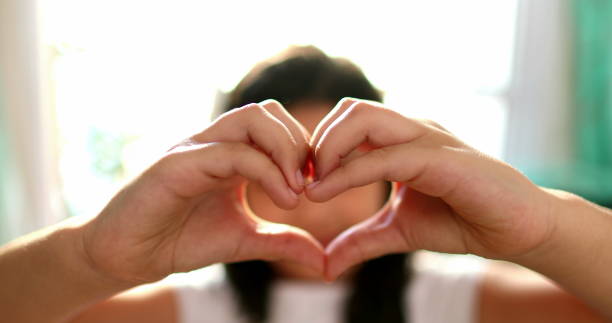 istock Cute child doing heart symbol sign with hands 1379163587