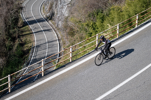Woman road cycling on Italian alpine road
