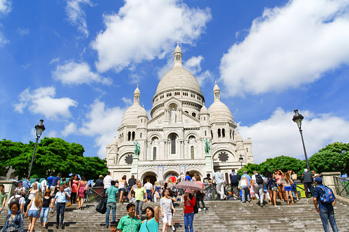 Paris, France - August 17, 2013: the Basilica of the Sacred Heart (Basilique du Sacre-Coeur) was built between 1873 and 1914 and consecrated in 1919 on Montmartre hill, Paris, France. A lot of people around.