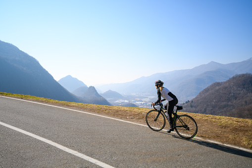 Woman road cycling on Italian alpine road