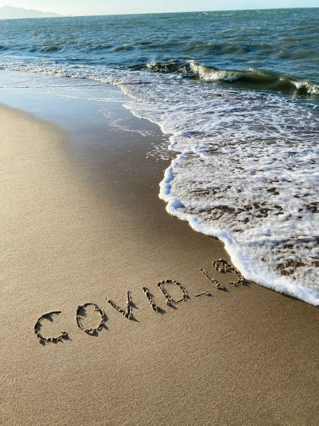 istock COVID-19 text on the sandy beach, coast and ocean in the background 1379169339