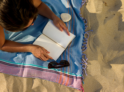 Woman on the beach reading a book