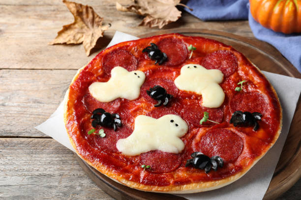 istock Cute Halloween pizza with ghosts and spiders served on wooden table 1379186777