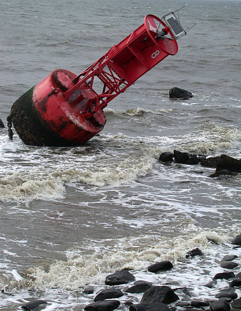 Channel Marker Washed up on Stormy shore a large red channel marker (roughly 25 feet tall) that washed up on the shore after Hurricane Isabel. channel marker stock pictures, royalty-free photos & images