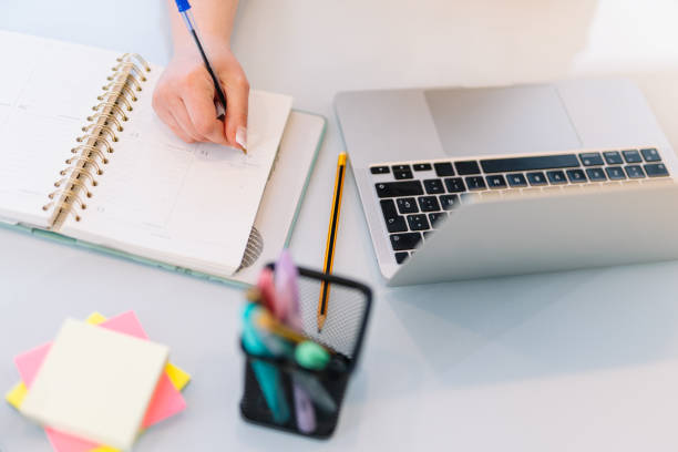 istock Hand of a young woman writing in a notebook 1379210202