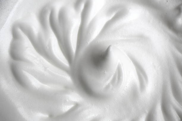 The texture of egg whites whipped into a large foam The texture of egg whites whipped into a large foam milk froth stock pictures, royalty-free photos & images