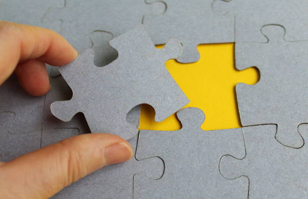 istock Hand holds gray puzzle on yellow background 1379240457