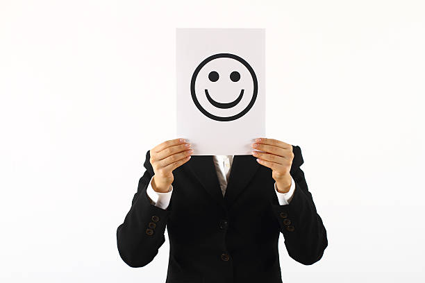 istock Man in a suit holding a smiley sign in front of his face 137924663