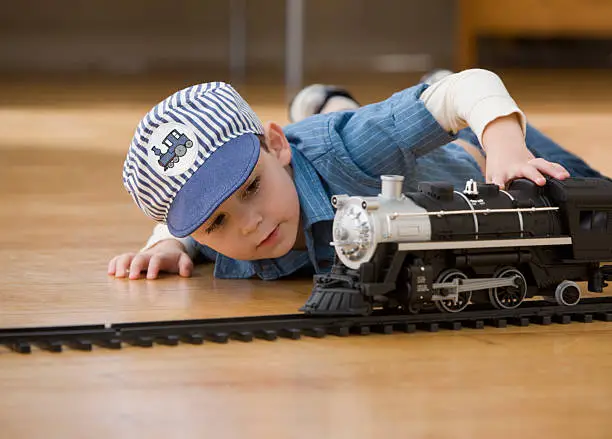 Photo of Young boy playing with toy trains