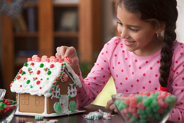 Girl decorating gingerbread house  gum drop photos stock pictures, royalty-free photos & images