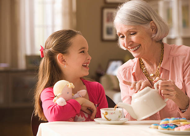 abuela y granddaughter tener tea party - tea party little girls teapot child fotografías e imágenes de stock