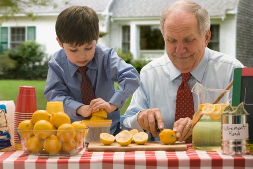 Grandfather and grandson cutting lemons for lemonade