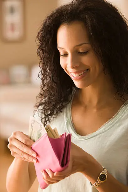 Photo of Young woman checking cash in wallet