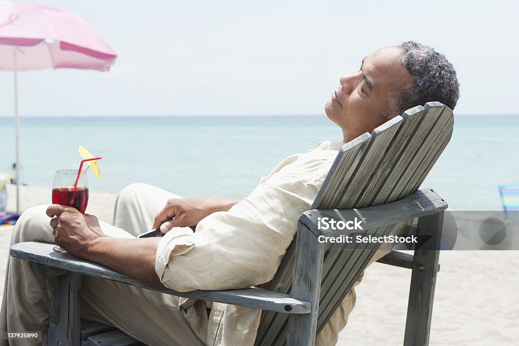 나이든 남자 비치 의자에 앉아 휴식을 음료 - 로열티 프리 남자 스톡 사진