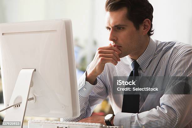 Serio Uomo Daffari Guardando Relazione Sul Computer - Fotografie stock e altre immagini di 25-29 anni