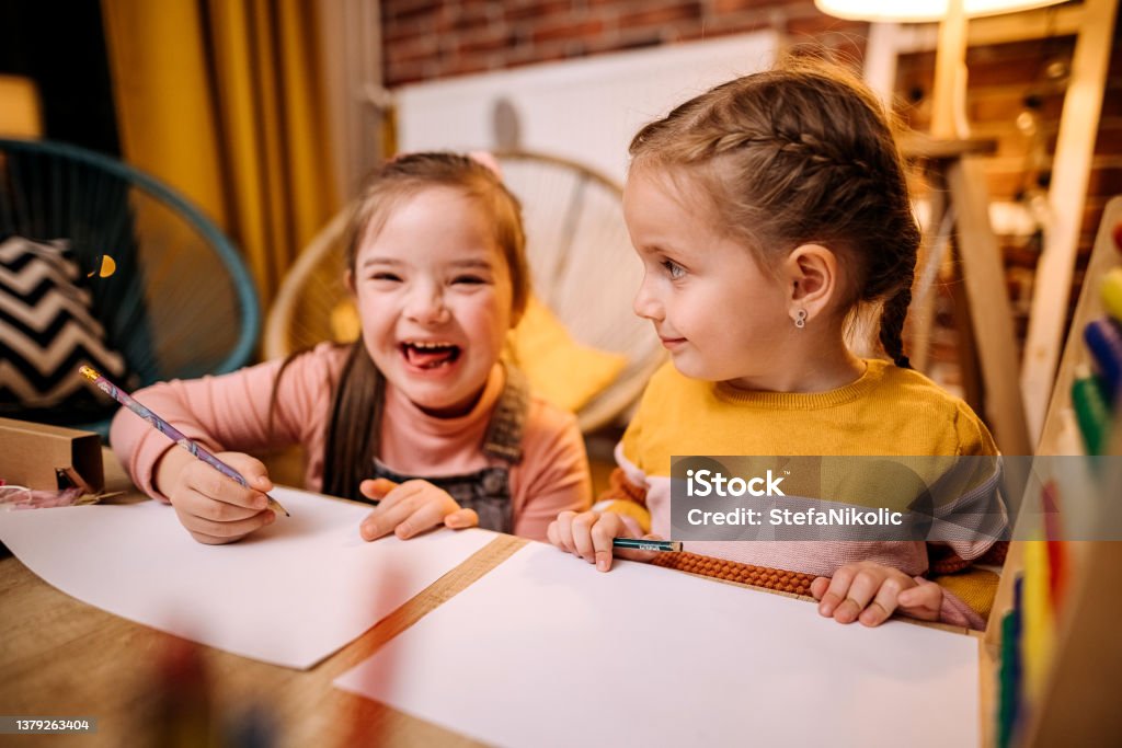 If we work quickly we can play Shot of two sisters completing their homework togethe Autism Stock Photo