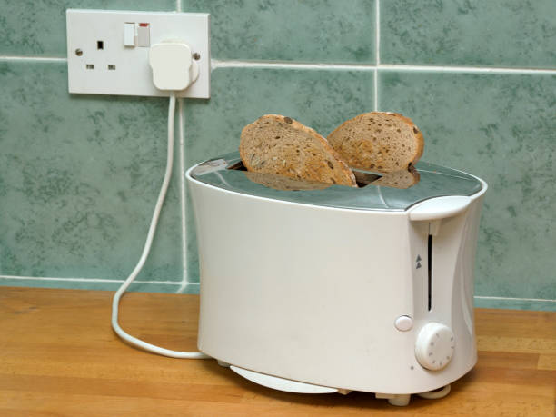 istock Electric Toaster with Toast, plugged in to wall socket 1379283505