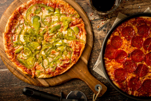istock Green pepper pizza and Pepperoni pizza on wood table 1379284052