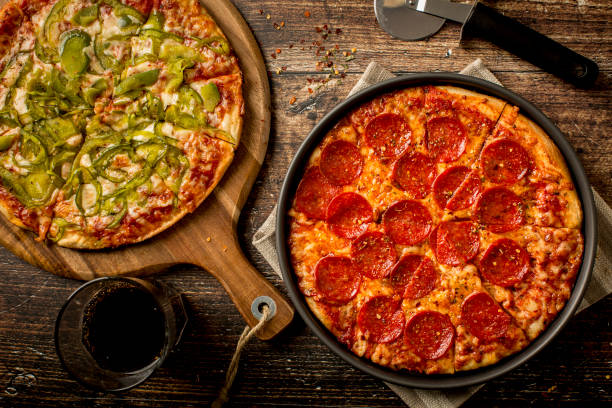 istock Green pepper pizza and Pepperoni pizza on wood table 1379284408