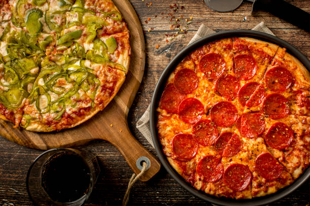 istock Green pepper pizza and Pepperoni pizza on wood table 1379284634